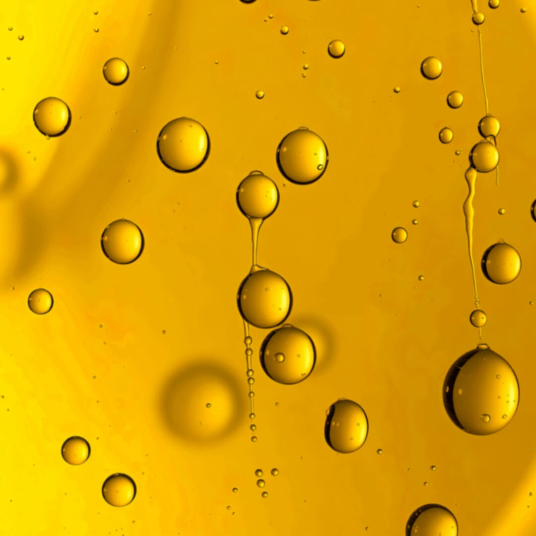 Close-up of Co Enzyme Q10 on a yellow liquid surface