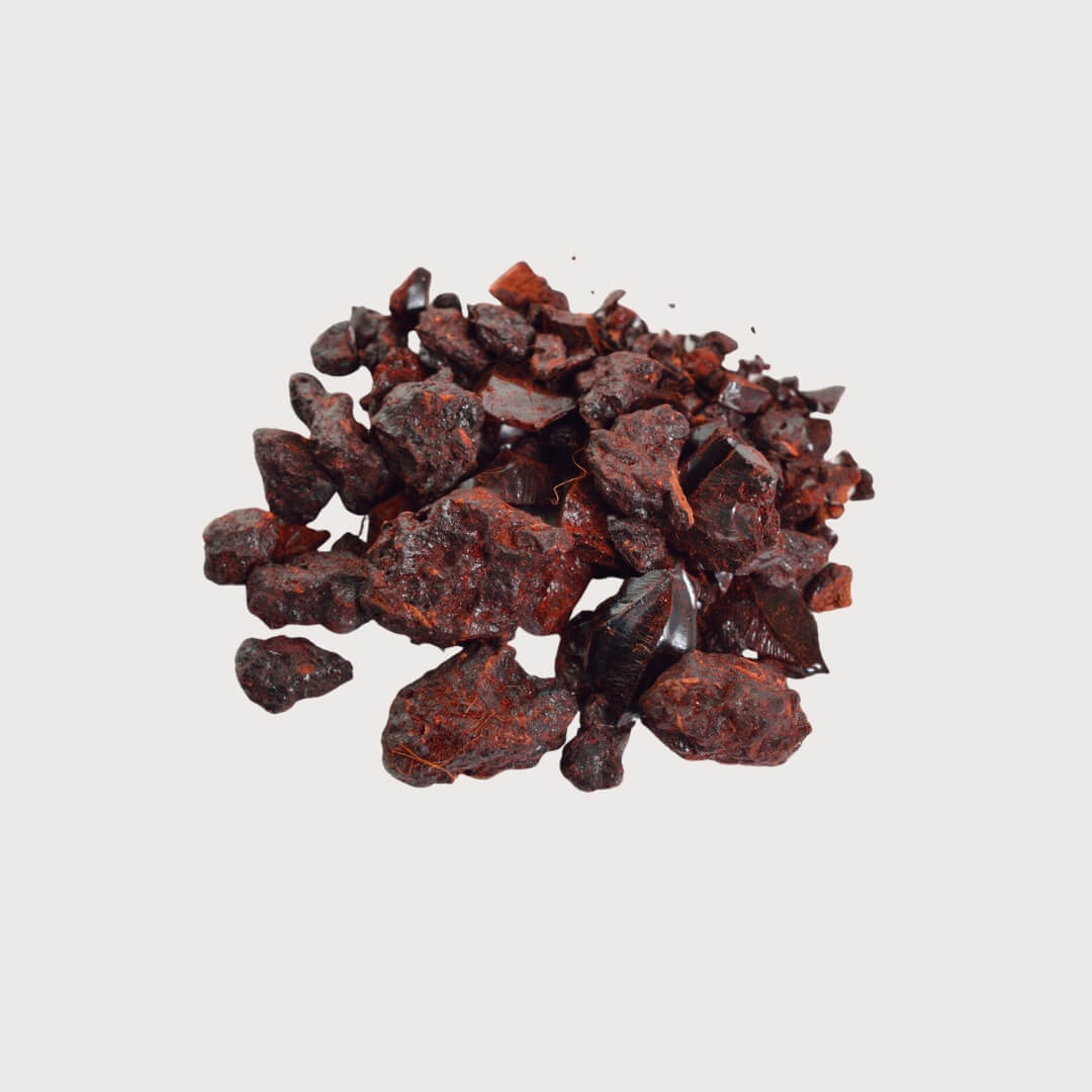 Pile of dark red dragons blood resin on a light gray background