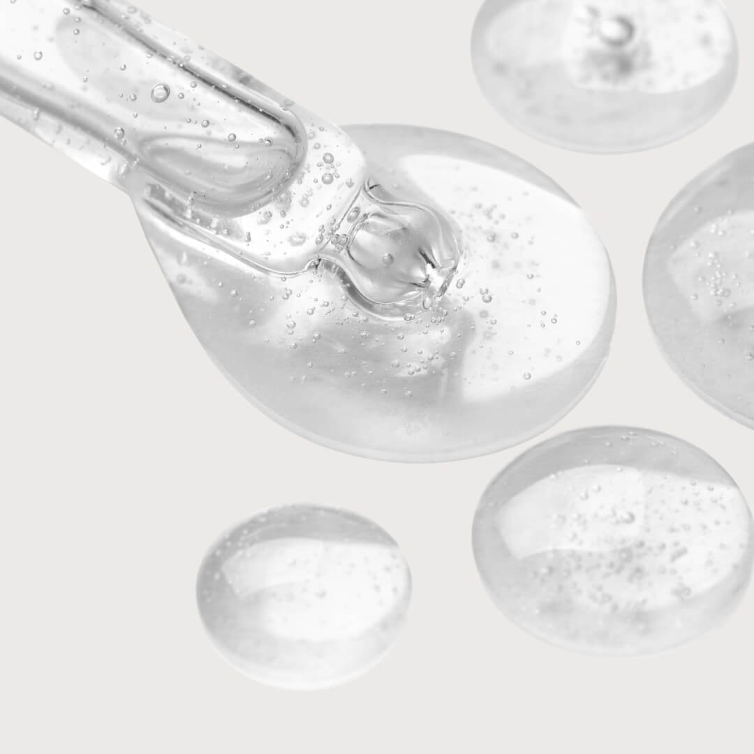 Close-up of a dropper with Niacinamide on a light gray background