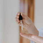 Woman dropping Reign Hyaluronic Serum into hand