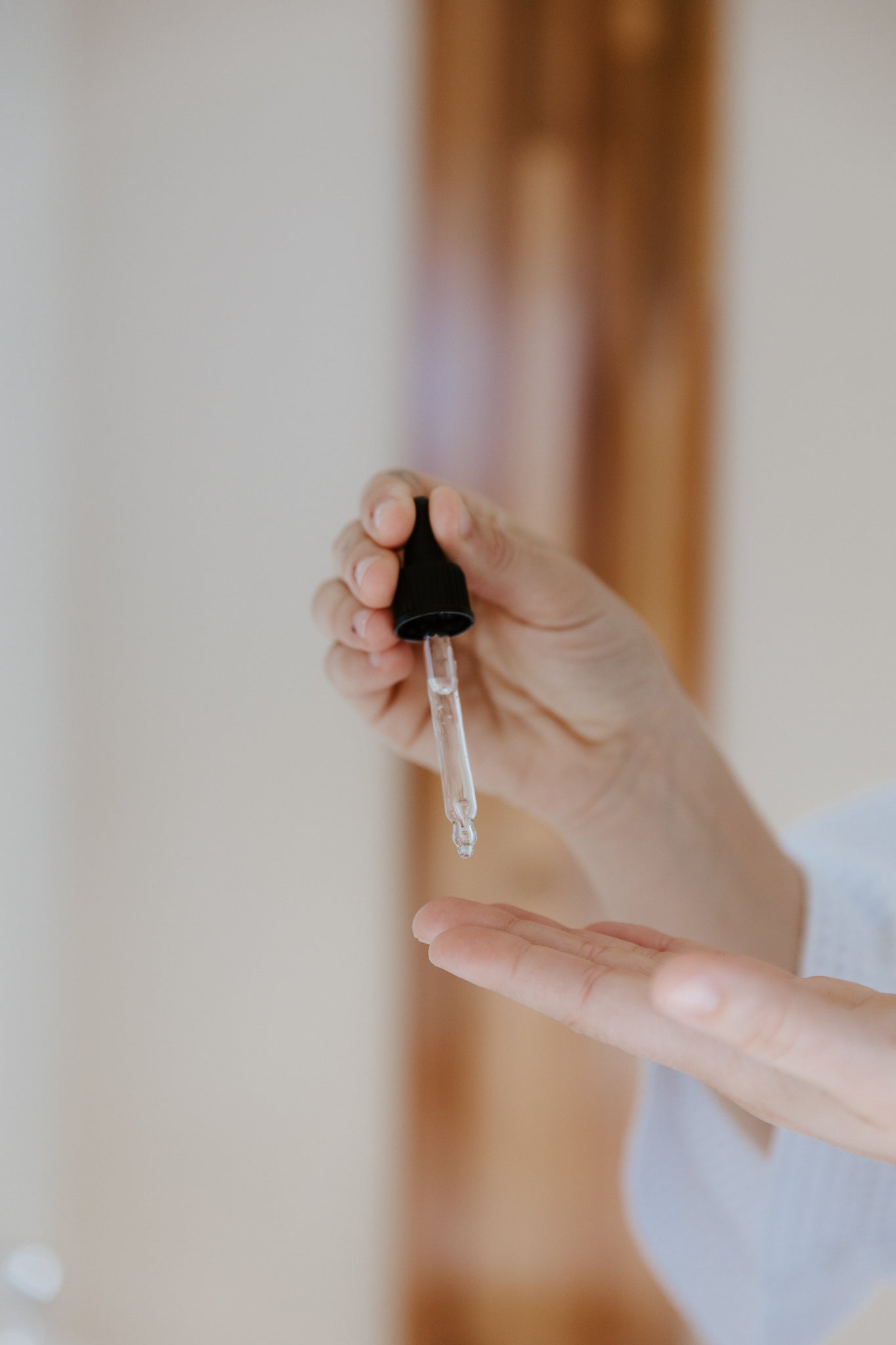 Woman dropping Reign Hyaluronic Serum into hand