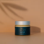 Jar of Reign rejuvenating night cream with a dark label on a warm background