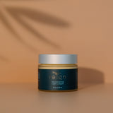 Jar of Reign rejuvenating night cream with a dark label on a warm background