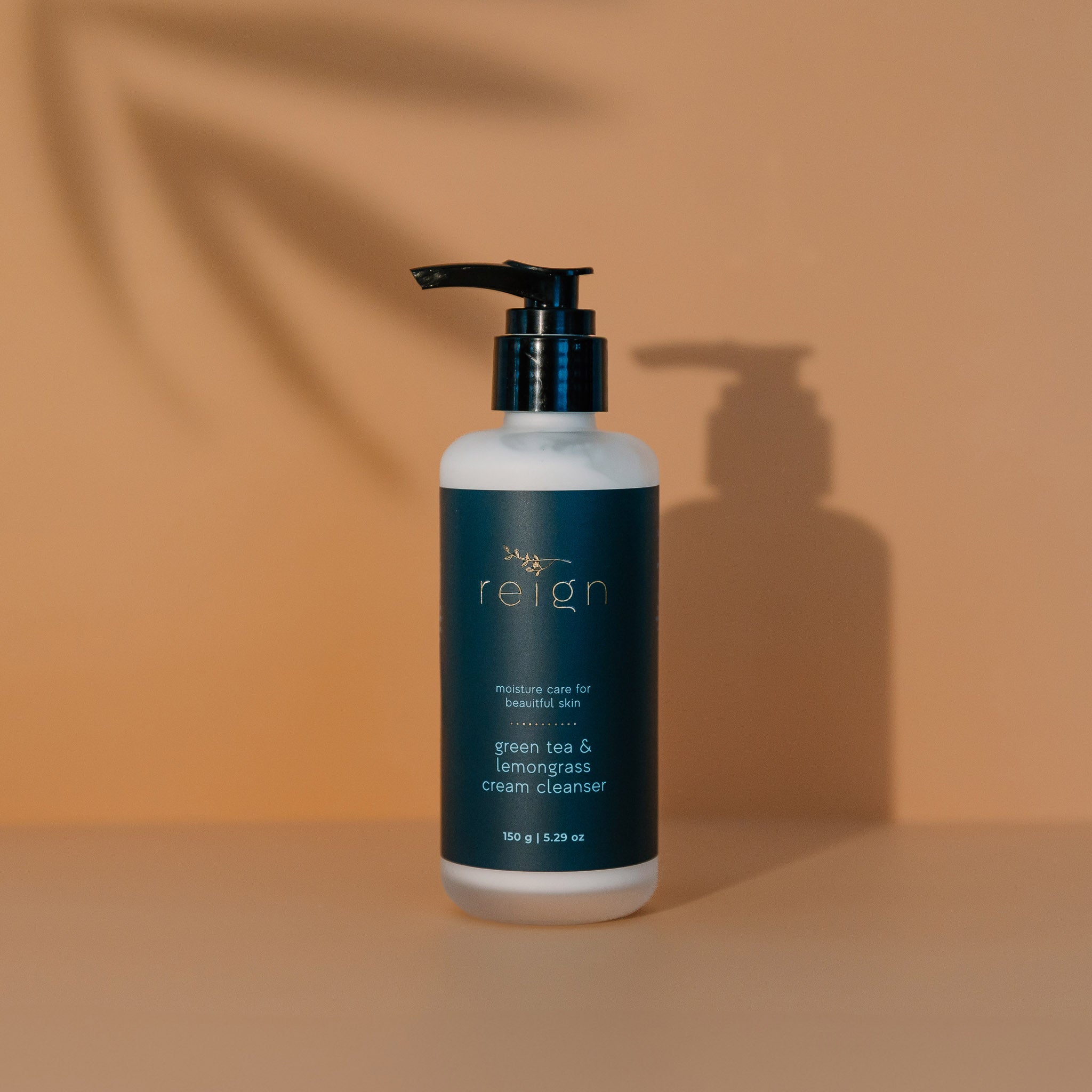 Bottle of 'reign' cream cleanser on a brown background
